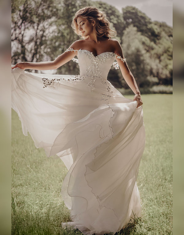 Georgia is full of romance and feminity. A sculpted sweetheart bodice is the base for a pretty petal detail that trails off the shoulder and continues through the full organza skirt.  A surprisingly light dress full of movement and fun!